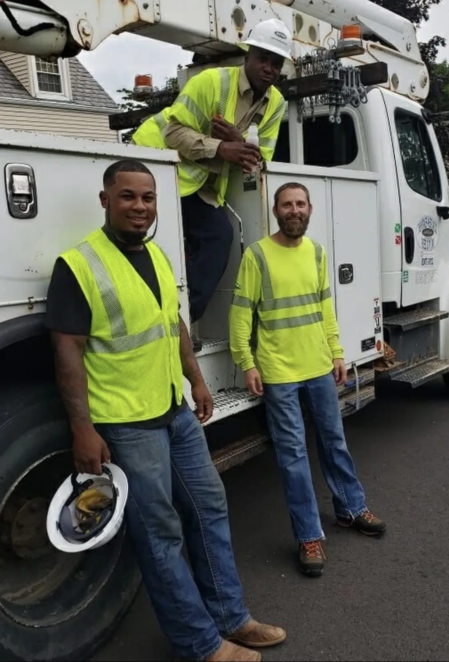 Three utility workers alongside a bucket truck