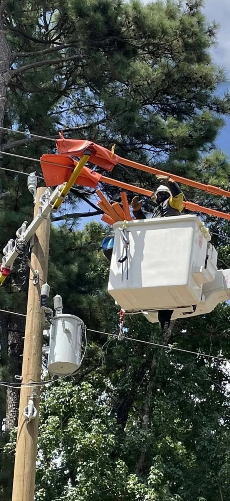 Lineworker in a bucket working near an overhead distribution pole