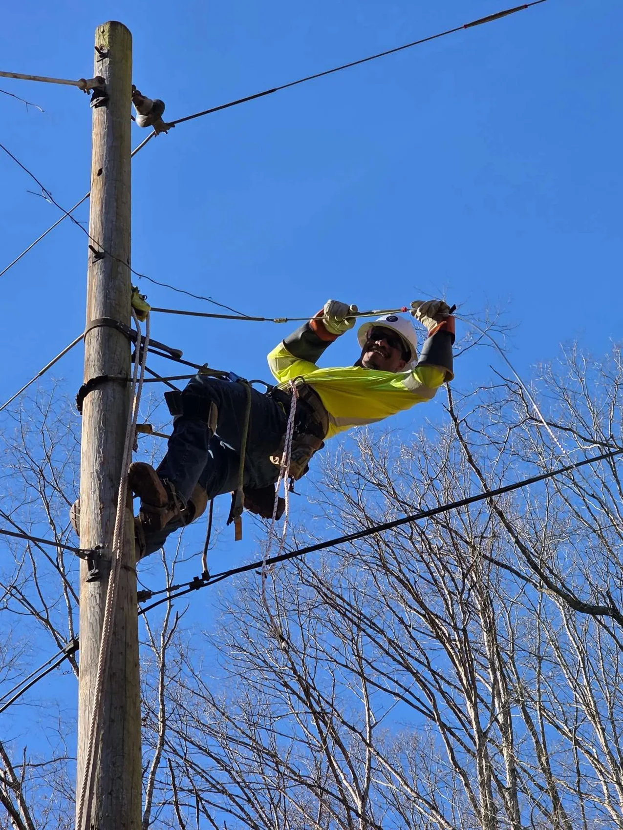Lineworker climbing and working on a utility pole