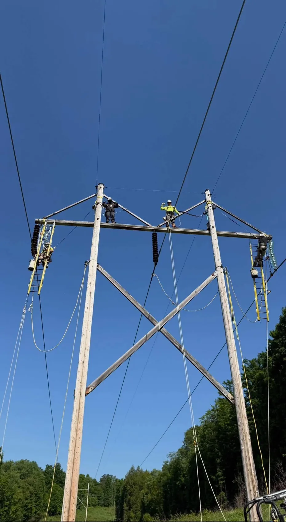 Transmission line crew working on a large overhead structure